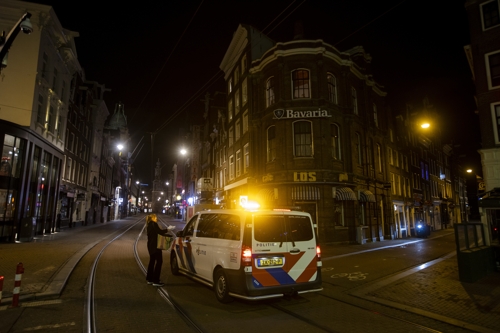 네덜란드 경찰이 지난 23일(현지시간) 수도 암스테르담에서 봉쇄 명령을 어긴 차량을 검문하고 있다. 네덜란드 정부는 이날부터 봉쇄 명령을 강화해 오후 9시부터 다음날 오전 4시30분까지 이동을 금지시켰다.  [이미지 출처= AP·연합]