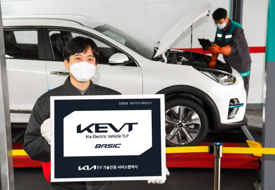기아 오토큐 정비 엔지니어가 'KEVT 베이직' 인증 현판을 선보이고 있다. <기아 제공>