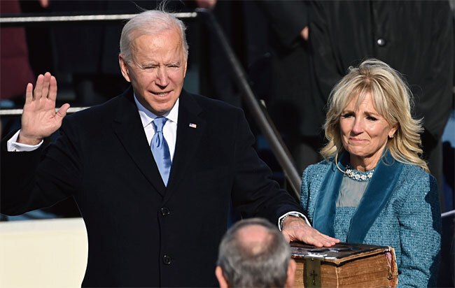 조 바이든(왼쪽) 미국 대통령이 1월 20일(현지시각) 워싱턴 D.C.의 연방의회 의사당에서 열린 취임식에서 질 바이든 여사와 함께 선서를 하고 있다. 사진 AP연합