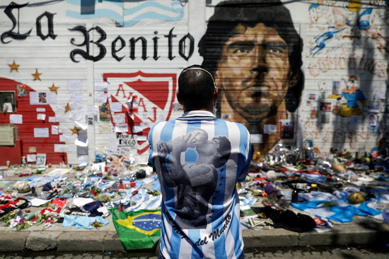 지난해 11월 아르헨티나 부에노스 아이레스의 한 길거리에서 축구팬이 디에고 마라도나의 얼굴이 새겨진 벽화 앞에 서서 마라도나를 추모하고 있다. /사진=로이터