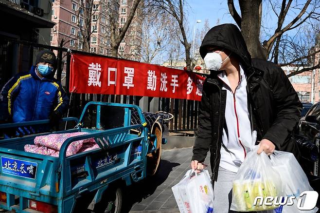 중국 베이징의 한 주택가에 신종 코로나바이러스 감염 예방을 위한 손세척 및 마스크 착용을 권장하는 현수막이 걸려있다. 중국 지역사회는 우한시에서 온 사람들을 적발해 신고한 자에게 현금 보상을 하고 있다. © AFP=뉴스1 © News1 정윤미 기자