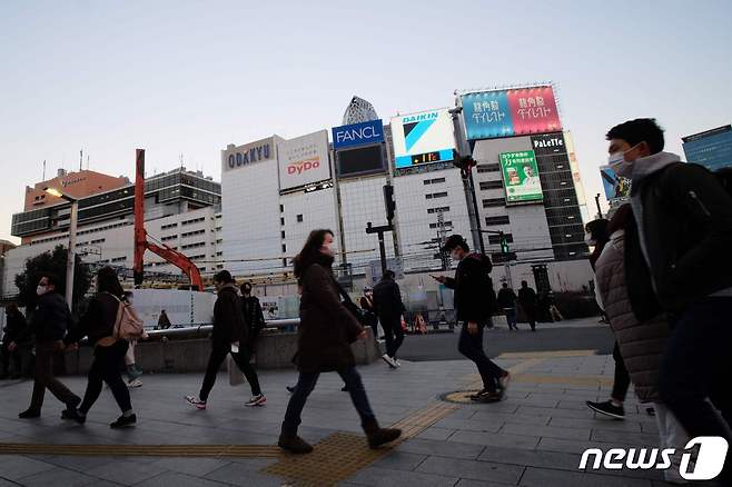 지난 13일 일본 도쿄 신주쿠구 거리를 마스크를 착용한 시민들이 지나가고 있다. © AFP=뉴스1