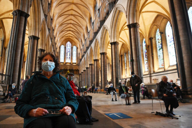 지난 20일(현지시간) 영국 잉글랜드의 800년된 솔즈베리 대성당에서 시민들이 코로나19 백신을 맞기 위해 오르간 연주 음악을 들으며 앉아있다. 솔즈베리|EPA연합뉴스