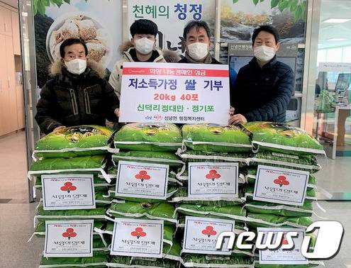 경북 영천시 정대만씨가 27일 아들 기포, 손자 원우씨(왼쪽부터)와 함께 신녕면 행정복지센테에 백미 40포대를 기부하고 있다. 정 씨는 38년간 기부를 해오고 있다. (영천시 제공) 2021.1.27/1