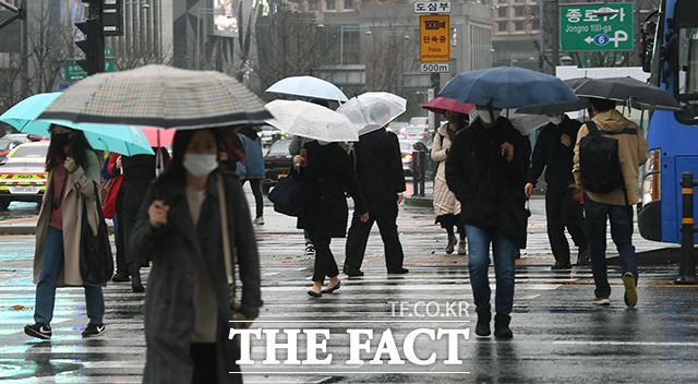 최근 확진자 추세가 유행 정점에 비해 크게 줄어든 가운데 주말 이동량이 2주 연속 증가한 것으로 나타났다. 19일 오전 서울 종로구 광화문역 일대의 시민들이 우산을 쓰고 발걸음을 재촉하고 있다. /이동률 기자