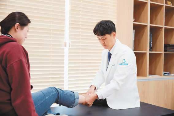 배의정 병원장(오른쪽)이 발목인대 파열 환자를 보고 있다. 관절 간의 유기적인 관계를 고려할 때 족부질환은 빠른 치료를 받는 것이 중요하다.