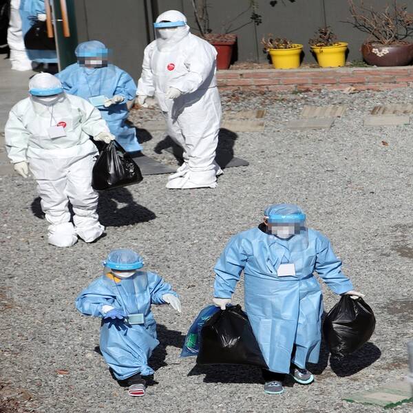 코로나19에 확진된 광주 티시에스(TCS)국제학교의 어린이 합숙생이 27일 낮 생활치료시설 입소를 위해 방호복을 입고 이동하고 있다. 이곳에서는 120여명이 합숙 생활을 하다가 113명이 코로나19에 확진됐다. 연합뉴스