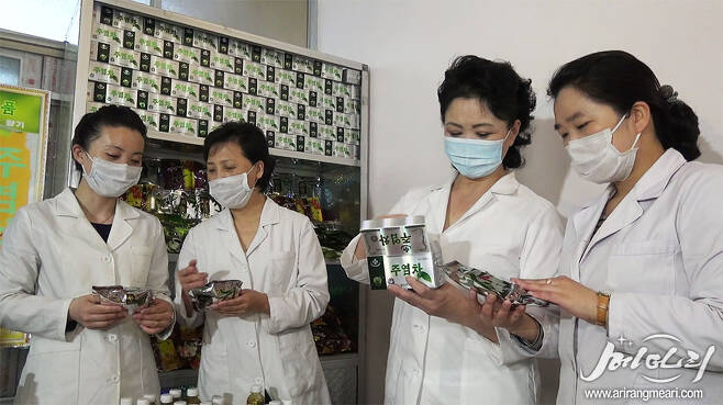 People holding Juyeom tea, a dietary supplement made out of natural herbs and tree oil extractions, known to help quit smoking. (Meari-Yonhap)