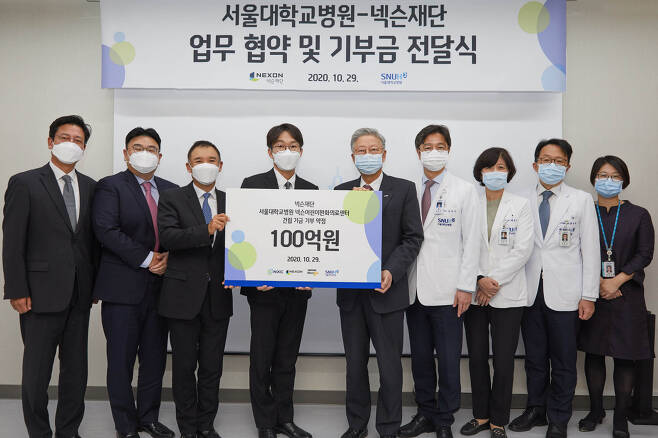 From left: Nexon Foundation Chairman Kim Jung-wook, Neople CEO Noh Jung-hwan, NXC CEO Kim Jung-ju and Nexon Korea CEO Lee Jung-hun pose for a photo with officials from Seoul National University Hospital at a donation ceremony held on Thursday. (Nexon)