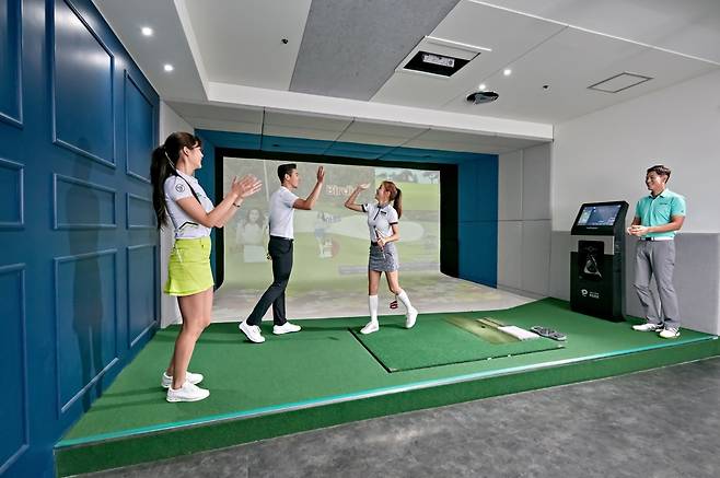 Users play the latest version of Golfzon’s indoor golf simulator. (Golfzon)