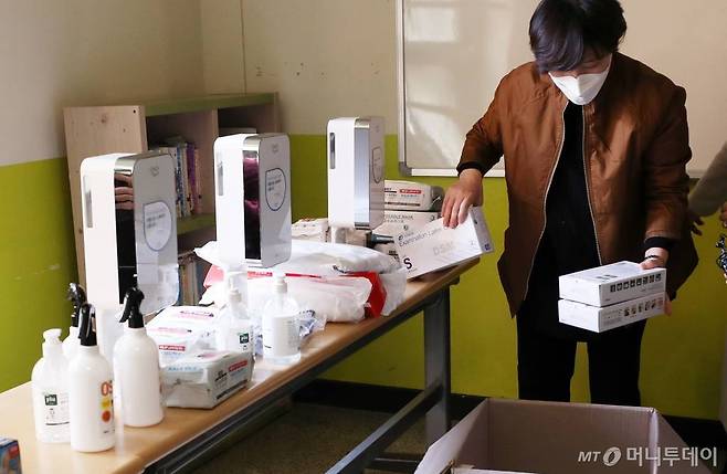 제21대 국회의원선거를 하루 앞둔 14일 오후 서울 종로구 청운초등학교에 마련된 투표소에서 선관위 관계자들이 손소독 용품을 확인하고 있다. / 사진=김휘선 기자 hwijpg@