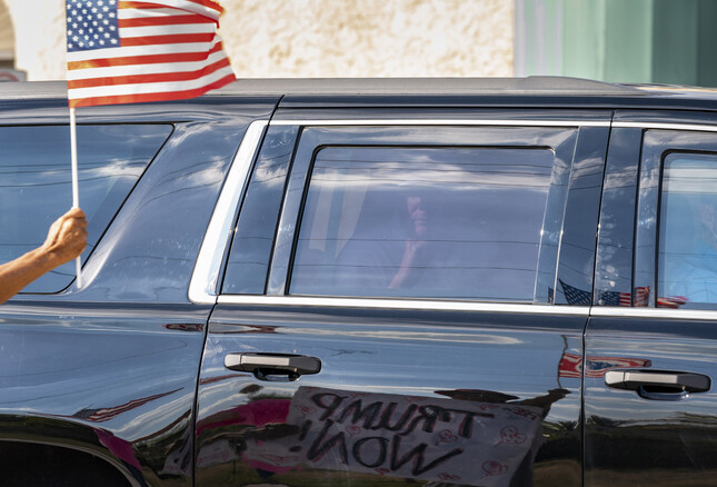 도널드 트럼프 전 미국 대통령이 탄 자동차가 27일 플로리다주 팜비치에서 성조기를 흔드는 지지자를 지나쳐 가고 있다. 팜비치/AP 연합뉴스