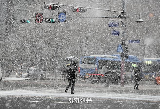 대설특보가 내린 28일 오전 시민들이 함박눈을 맞으며 서울 세종로네거리를 지나가고 있다. 기상청은 눈이 그치고 매서운 한파가 찾아온다고 예보했다. 강윤중 기자