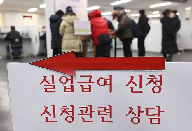 A group of people fill out applications for unemployment benefits at a regional office of the Employment and Welfare Plus Center in Seoul earlier this month. (Yonhap)
