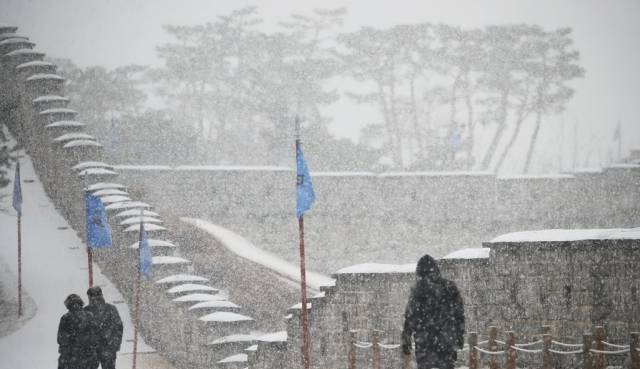 28일 오전 경기도 수원시 팔달구 세계문화유산 화성(華城)에서 시민들이 눈을 맞으며 성곽길을 걷고 있다. 연합뉴스