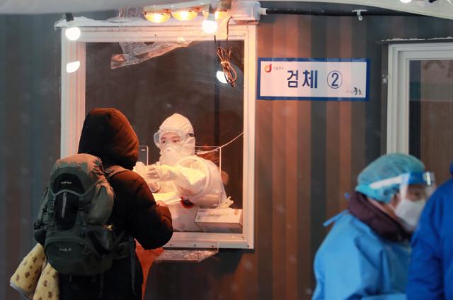 30일 서울역광장에 마련된 신종 코로나바이러스 감염증(코로나19) 임시 선별진료소에서 의료진이 검체를 채취하고 있다. 뉴스1