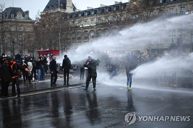 물대포에 맞서는 프랑스의 보안법 항의 시위대 (파리 AFP=연합뉴스) 프랑스의 포괄적 보안법에 반대하는 시위대가 30일(현지시간) 파리의 거리에서 경찰의 물대포에 맞서고 있다. jsmoon@yna.co.kr