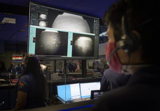 미 항공우주국(NASA) 직원들이 18일(현지시간) 화성 표면에 착륙한 탐사선 퍼시비어런스가 전송한 사진을 보고 있다. [사진=NASA]