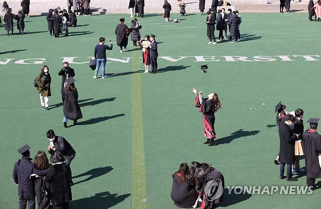 코로나 속 졸업식 풍경 (서울=연합뉴스) 이진욱 기자 = 18일 서울 마포구 서강대학교에서 졸업생들이 거리를 두며 기념촬영을 하고 있다. 보건복지부 중앙사고수습본부는 교내에서 '단체 사진'을 찍는 것까지는 '5인 이상 사적모임 금지'에 해당하지 않는다고 밝혔다. 2021.2.18 cityboy@yna.co.kr