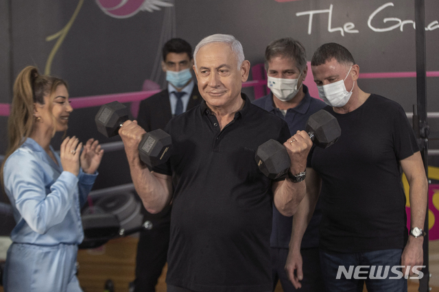 [페타 티크바=AP/뉴시스] 20일 이스라엘의 네타냐후 총리가 3차 록다운 해제를 앞두고 피트내스 짐을 찾아 운동기구를 들어보이고 있다