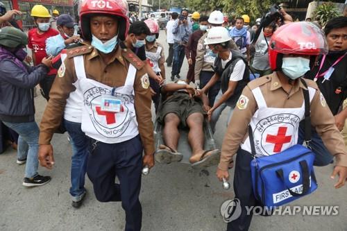 만달레이에서 군경의 총격으로 부상한 시위 참가자가 옮겨지고 있다. 2021.2.21 [로이터=연합뉴스. 재판매 및 DB 금지]