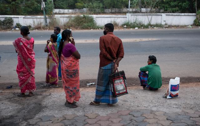 인도 케랄라주 고치에서 출근하려는 일용직 근로자들이 자기들을 태워 갈 차를 기다리고 있다. 고치=AP 연합뉴스