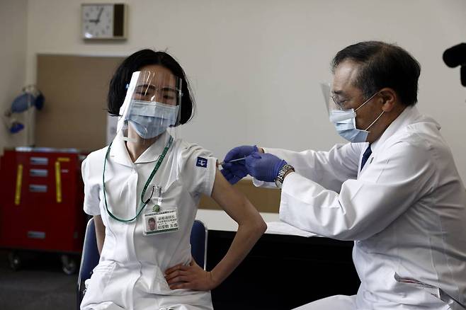 이달 17일 일본 도쿄의 도쿄 의료센터에서 한 의료인이 코로나19 백신을 접종하고 있다. 일본은 17일 백신의 안정성 확인을 위해 4만여 명의 의료계 종사자를 선행 대상으로 코로나19 백신 접종을 시작했다. /사진=[도쿄=AP/뉴시스]