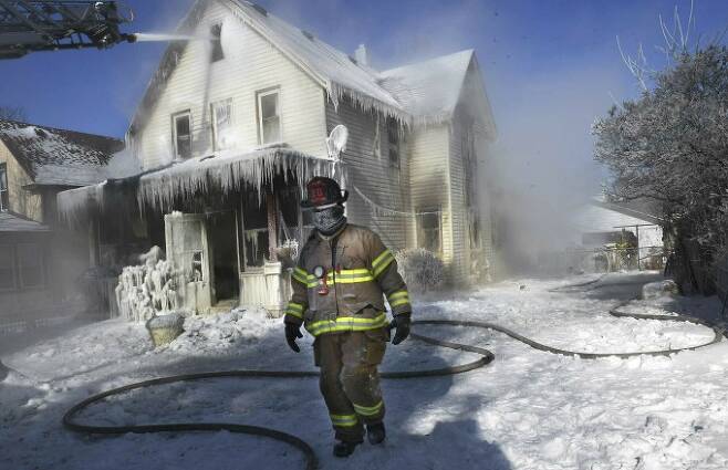 미국 미네소타주에 한파가 찾아온 모습. 화재 진압 현장의 소방관과 얼어있는 집이 보인다. AP/연합뉴스 제공