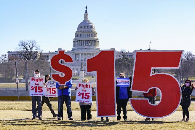 활동가들이 25일(현지시간) 미국 워싱턴 의회 앞에서 최저임금 15달러 인상을 요구하는 시위를 벌이고 있다. 워싱턴|AP연합뉴스