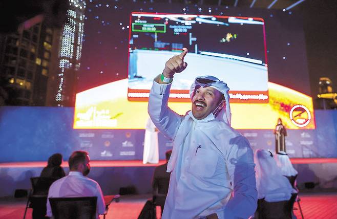 아랍에미리트 두바이의 거리에서 한 시민이 화성 탐사선 아말호의 화성 궤도 진입 성공에 기뻐하고 있다. [로이터]