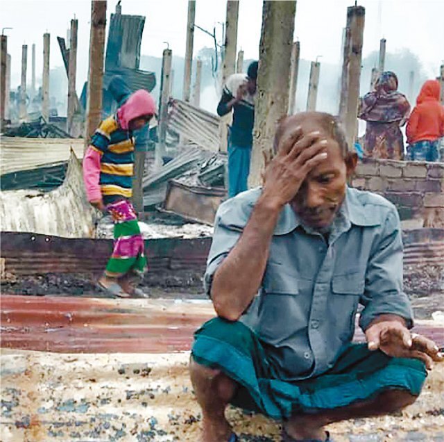 지난달 14일 미얀마 국경에 있는 방글라데시 콕스바자르 난민촌서 로힝야족 난민 남성이 화재로 불타 버린 잔해 위에 망연자실한 표정으로 앉아 있다. 2018년 기준 130만 명이 넘는 로힝야족 난민이 고향으로 돌아가지 못하고 방글라데시에 머물고 있다. 콕스바자르=AP 뉴시스