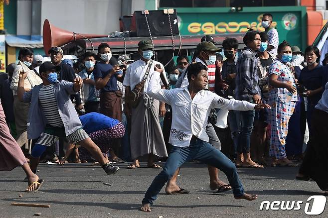 25일(현지시간) 군사 쿠데타를 규탄하는 대규모 시위가 발생한 미얀마 양곤에서 군부 지지자들이 시위대를 향해 돌을 던지고 있다. © AFP=뉴스1 © News1 우동명 기자