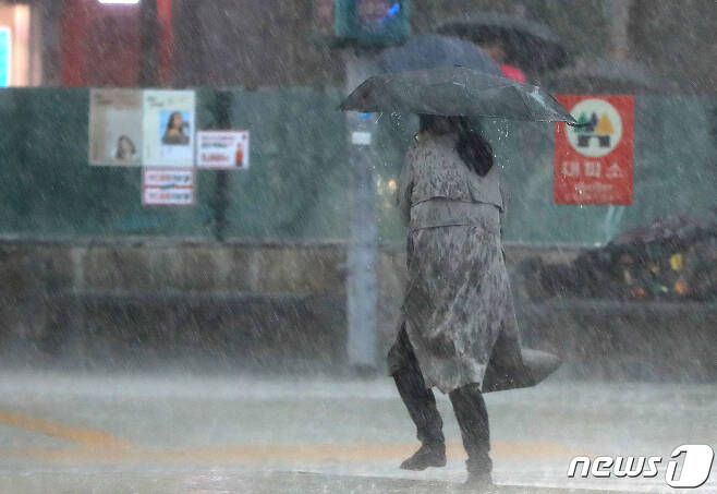지난해 5월18일 오후 서울 광화문네거리에서 시민들이 갑자기 내린 폭우에 발걸음을 옮기고 있다. 2020.5.18/뉴스1 © News1 구윤성 기자