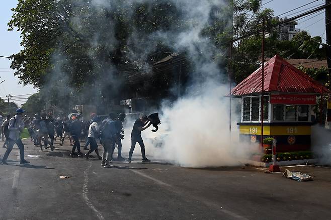 28일(현지 시각) 미얀마 양곤에서 군부 쿠데타에 저항하는 시민들이 군경의 최루탄을 맞고 있다. /AFP 연합뉴스