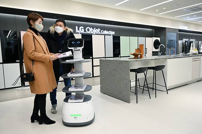 LG베스트샵, 로봇 직원 채용 LG베스트샵 서울 서초본점에서 28일 고객들이 LG 클로이 서브봇이 가져다준 안내 책자를 살펴보고 있다. LG전자는 연내에 전국의 주요 LG 베스트샵에 LG 클로이 서브봇과 LG 클로이 바리스타봇 등 로봇을 확대 도입할 예정이다. LG전자 제공