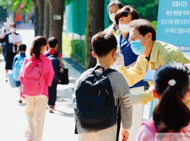 지난해 5월 조희연 교육감이 대면 등교가 시작된 서울 송파구의 한 초등학교에서 발열 체크를 돕는 모습.