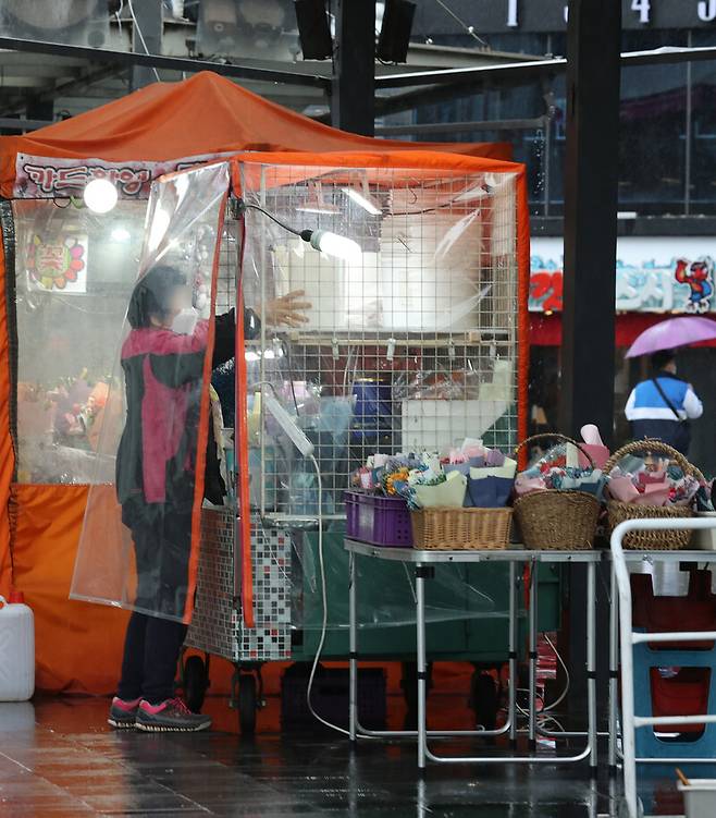 1일 오후 서울 종로구 관철동 젊음의 거리에서 노점 상인들이 비가 오는 가운데 영업을 준비하고 있다. 연합뉴스