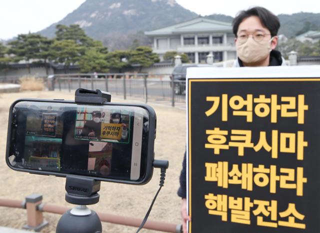 지난달 25일 청와대 분수대 앞에서 녹색연합 관계자가 일본 후쿠시마 원전 사고 10주년을 앞두고 원전 폐쇄를 촉구하는 전국동시다발 1인 시위를 하고 있다. 연합뉴스