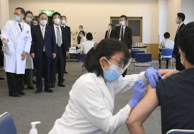 스가 요시히데(위 왼쪽 2번째) 일본 총리가 지난 18일 국영 도쿄메디컬센터에서 코로나19 백신 접종을 지켜보는 모습. 연합뉴스