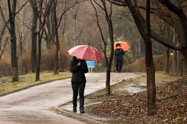 봄비가 내렸던 지난달 25일 광주 서구 5·18기념공원에서 시민들이 우산을 쓰고 산책하고 있다. /연합뉴스