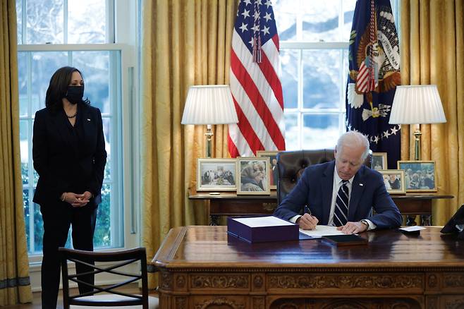 U.S. President Biden signs the American Rescue Plan in Washington - 조 바이든 미국 대통령이 카멀라 해리스 부통령이 지켜보는 가운데 11일(현지시간) 백악관 오벌오피스에서 1조 9000억 달러(약 2100조원) 규모의 코로나19 구제법안에 서명하고 있다.워싱턴DC 로이터 연합뉴스