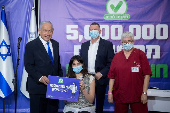 베냐민 네타냐후(왼쪽 첫 번째) 이스라엘 총리가 8일 텔아비브에서 코로나 백신 1차 접종을 500만 번째로 마친 한 여성과 포즈를 취하고 있다. 이스라엘은 작년 12월 19일 코로나 백신 접종을 개시했다. /신화연합뉴스