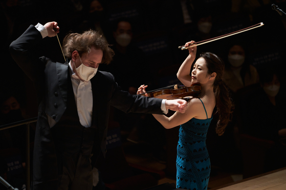 Violinist Kim Bomsori, right, playing Tchaikovsky's ″Violin Concerto″ under the baton of Venezuelan conductor Christian Vasquez on Friday to kick off this year's TIMF. [TIMF]