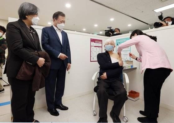 국내 첫 코로나19 백신 접종이 시작된 지난달 26일 문재인 대통령과 정은경 질병관리청장이 코로나19 백신 접종 참관을 위해 서울 마포구보건소를 방문해 백신 접종을 받는 김윤태 푸르메 넥슨어린이 재활병원 의사를 지켜보고 있다. 뉴시스