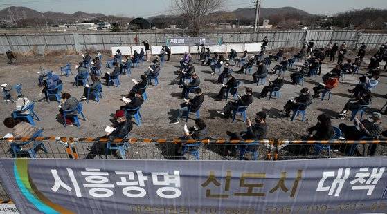 지난 3월 5일 오후 경기도 시흥시 과림동 소재 공터에서 열린 시흥·광명 신도시 대책 주민설명회를 찾은 주민들이 신도시 공사 계획 등을 듣고 있다. 뉴스1