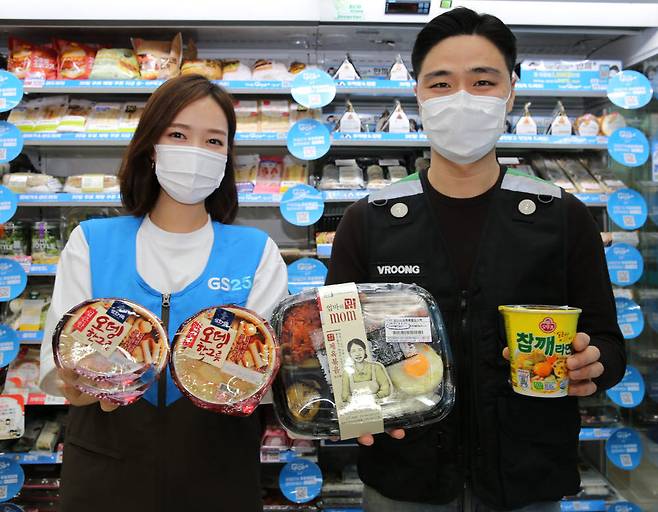 GS25에서 직원과 배달원이 4월 행사 상품을 소개하고 있다.