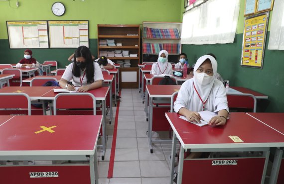 지난 3월 23일(현지시간) 인도네시아 자카르타 외곽 브카시의 한 학교 교실에 학생들이 코로나19 확산 방지를 위해 사회적 거리를 두고 앉아 있다. AP뉴시스