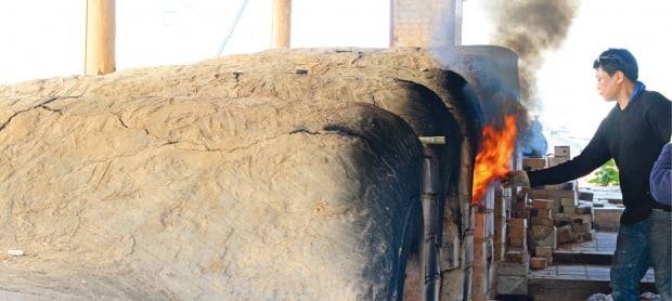 이천도자예술마을 안에 있는 가마에서 한 도예인이 소성작업을 하고 있다. 도자예술마을의 도예인들은 아직도 흙가마에 나무로 도자를 구워내는 전통방식을 선호한다.