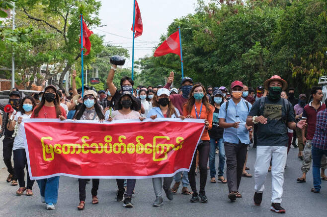 미얀마 시위대가 만달레이 군사 쿠데타에 반대하는 시위에 참여하면서 현수막을 들고 있다.(사진=로이터)