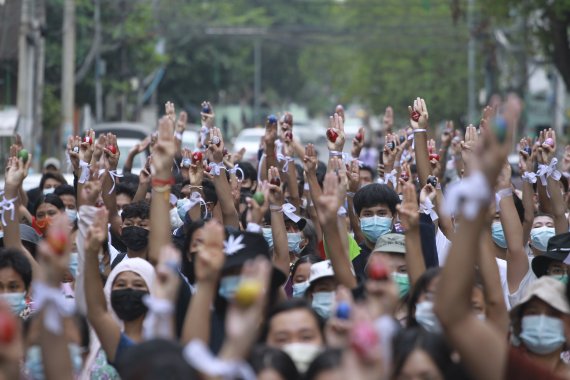 [양곤=AP/뉴시스] 4일 미얀마 최대도시에서 쿠데타 저항시위대가 그림 그려진 부활절 달걀과 함께 쓰리핑거스 경례 시위를 하고 있다 /사진=뉴시스